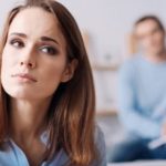 worried-woman-sitting-in-front-of-her-partner